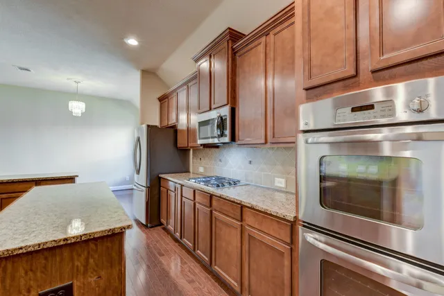 a kitchen with stainless steel appliances granite countertop a sink stove and cabinets