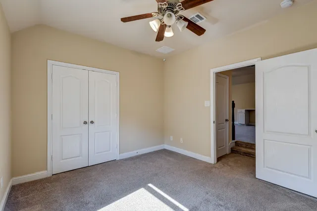 an empty room with a window and a ceiling fan