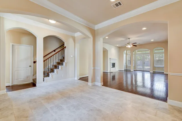 a view of a hallway with wooden floor and windows