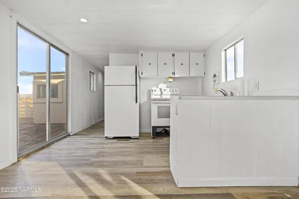 a kitchen with white cabinets and white appliances