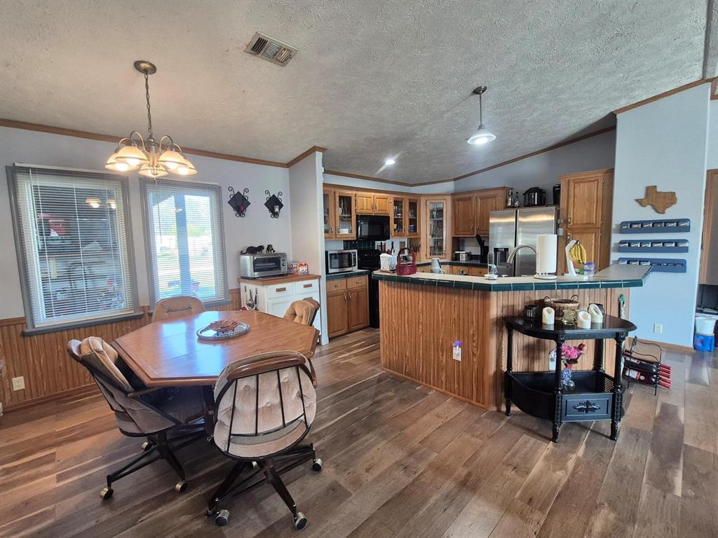 438 Silver River Road Gholson, TX 76705 - Photo 11 of 39 a view of a dining room with furniture wooden floor and chandelier