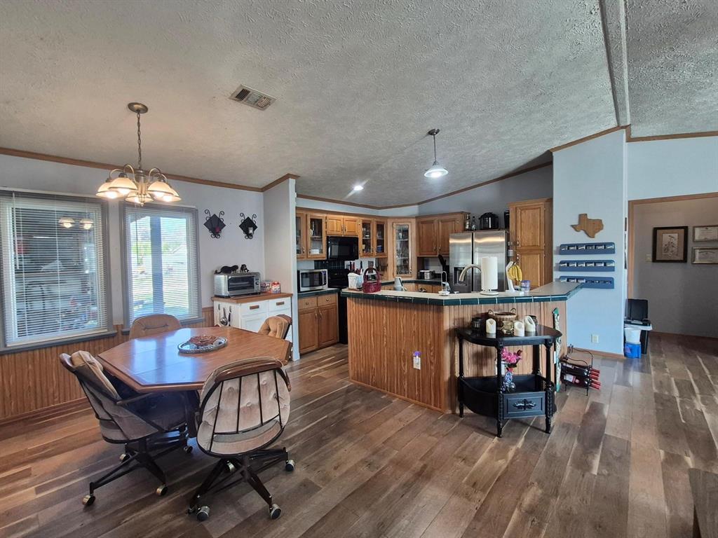 438 Silver River Road Gholson, TX 76705 - Photo 13 of 39 a dining room with furniture a chandelier and wooden floor