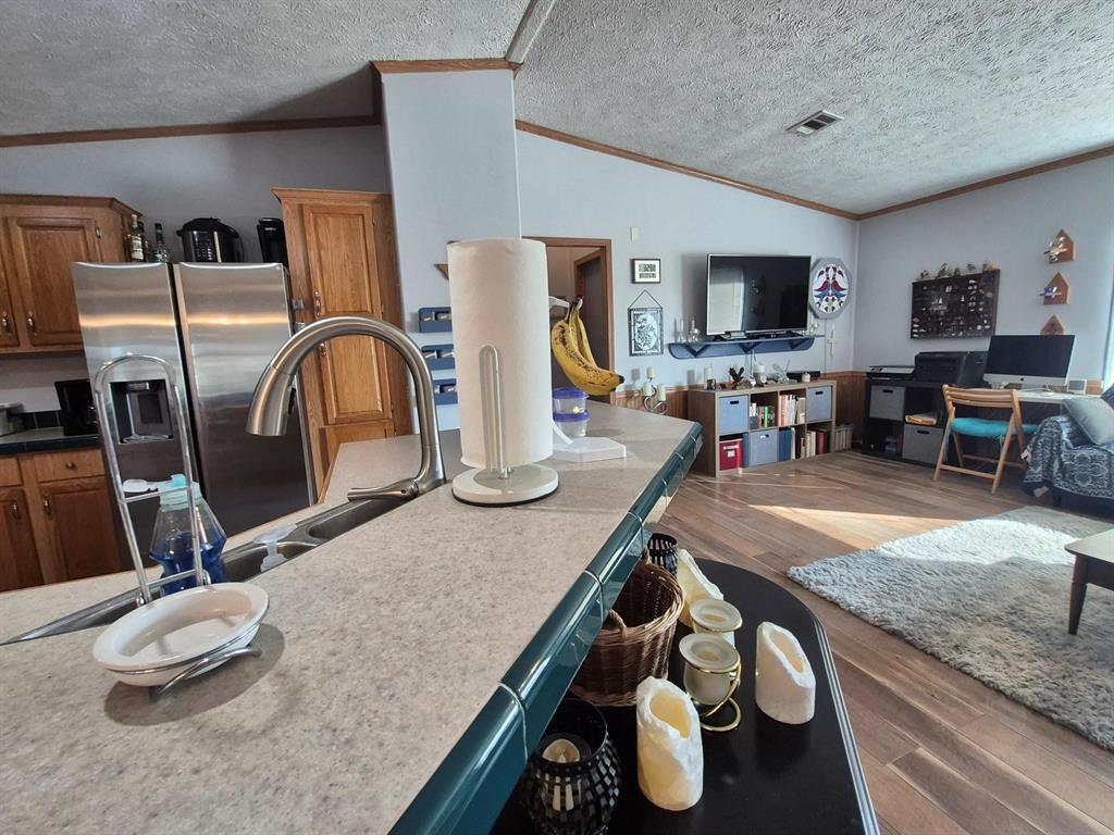 438 Silver River Road Gholson, TX 76705 - Photo 18 of 39 a kitchen with stainless steel appliances granite countertop a sink dishwasher and a microwave with wooden floor