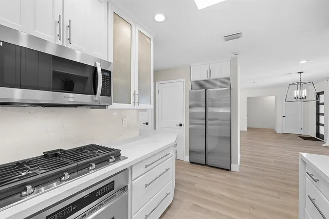 a kitchen with stainless steel appliances a stove microwave and refrigerator