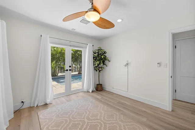 a view of a livingroom with a chandelier fan and windows