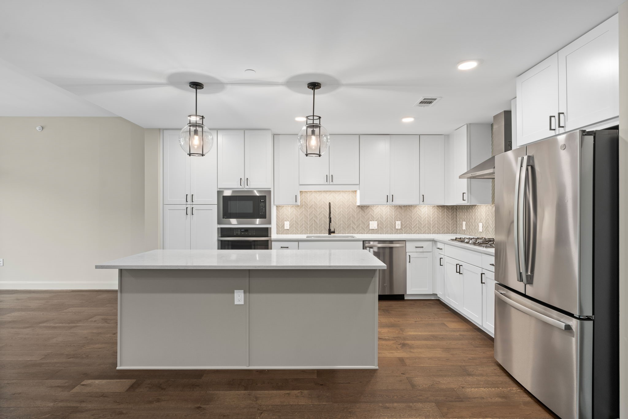 2511 Willowick Road, Unit 539 Houston, TX 77027 - Photo 2 of 45 a kitchen with stainless steel appliances granite countertop a refrigerator a sink dishwasher a stove and white countertops with wooden floor