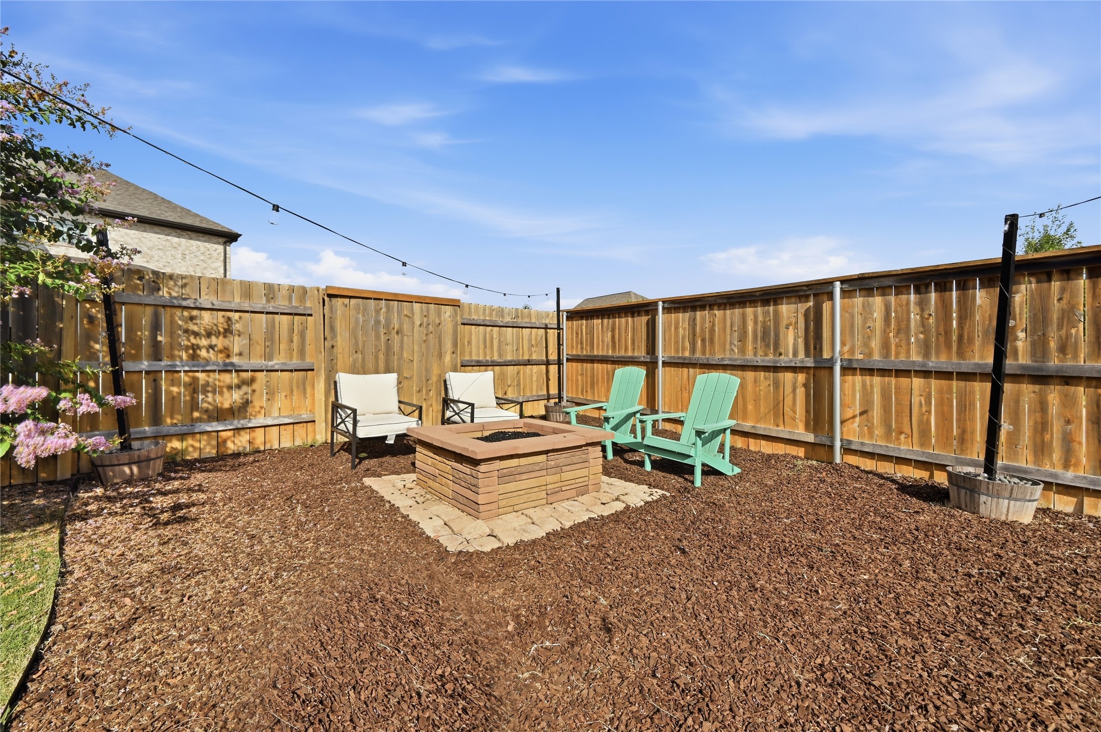 426 Cold Riv Run Kyle, TX 78640 - Photo 31 of 34 A well-maintained fenced yard offers a cozy fire pit and Adirondack chairs for outdoor relaxation.