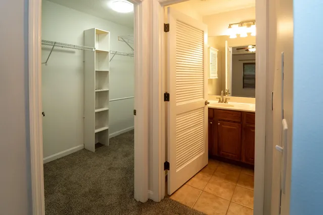 a view of a white house with a yard and table and chairs under wooden fence