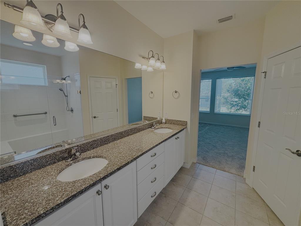 4859 Northwest 35th Ln Road Ocala, FL 34482 - Photo 17 of 30 a bathroom with a granite countertop double vanity sink and mirror