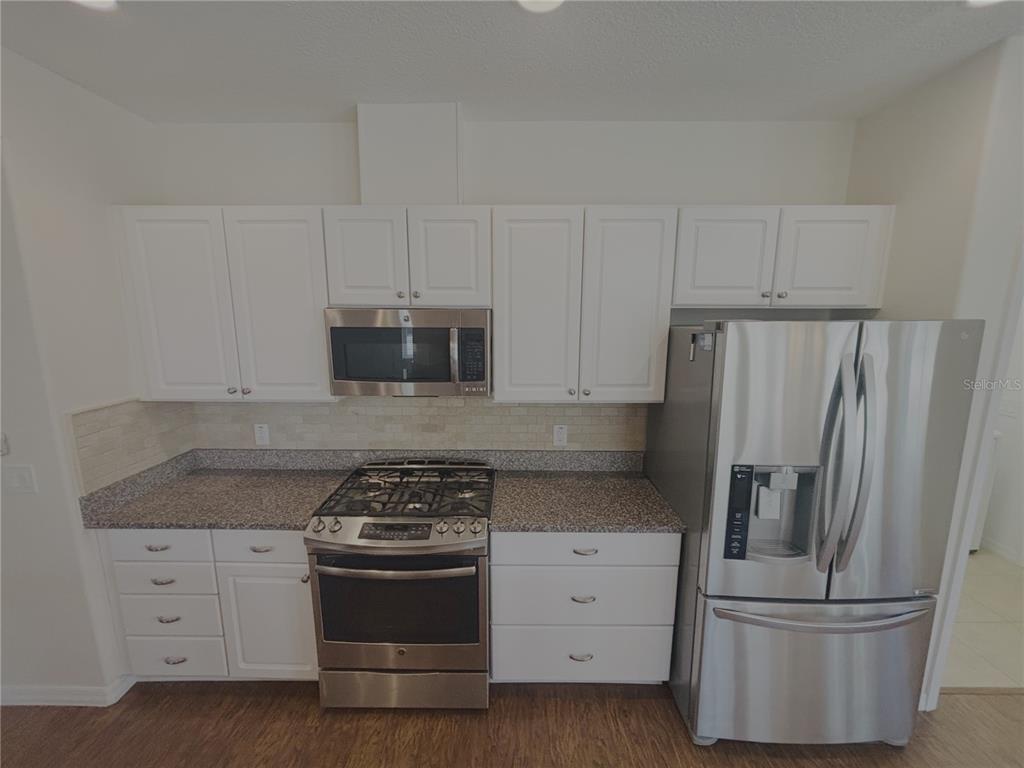 4859 Northwest 35th Ln Road Ocala, FL 34482 - Photo 3 of 30 a kitchen with granite countertop white cabinets and stainless steel appliances