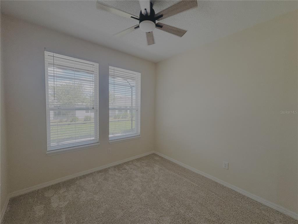 4859 Northwest 35th Ln Road Ocala, FL 34482 - Photo 9 of 30 an empty room with a window and a fan