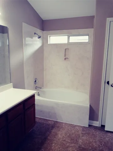 a spacious bathroom with a bathtub sink and mirror