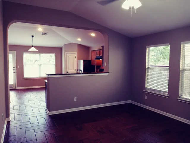 a view of a room with a window and wooden floor