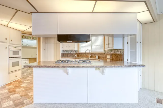 a kitchen with stainless steel appliances granite countertop a sink and a stove