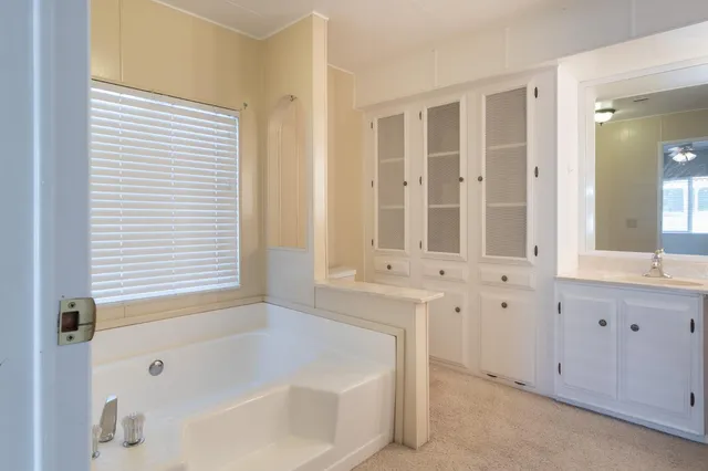 a bathroom with bathtub next to a window