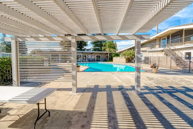 a view of a patio with a table and chairs next to a yard