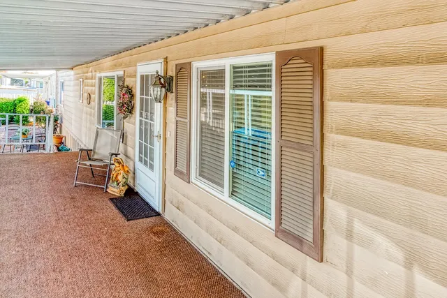 a view of a porch with a table and chairs and floor to ceiling window