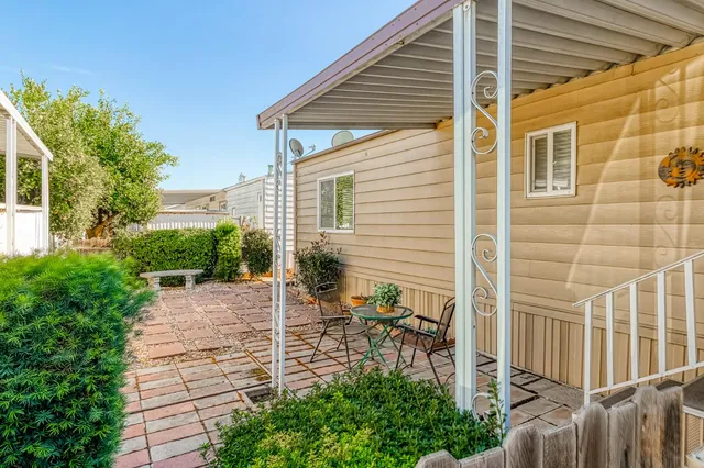 a view of a patio with table and chairs with wooden fence and plants