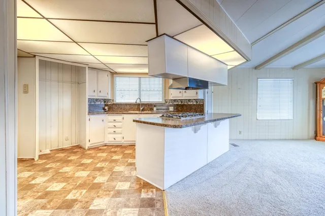 a kitchen with stainless steel appliances granite countertop a sink stove and cabinets