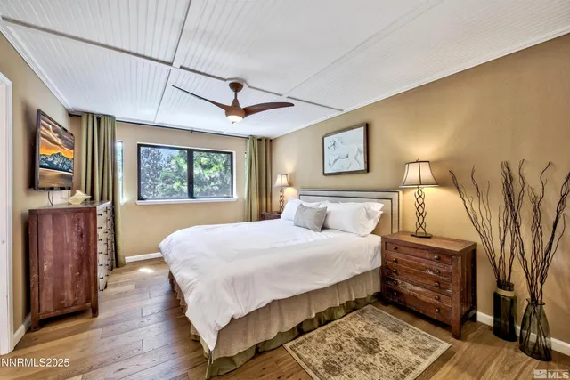 a bedroom with a large bed and a chandelier