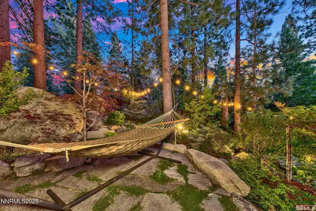 a front view of a house with large trees