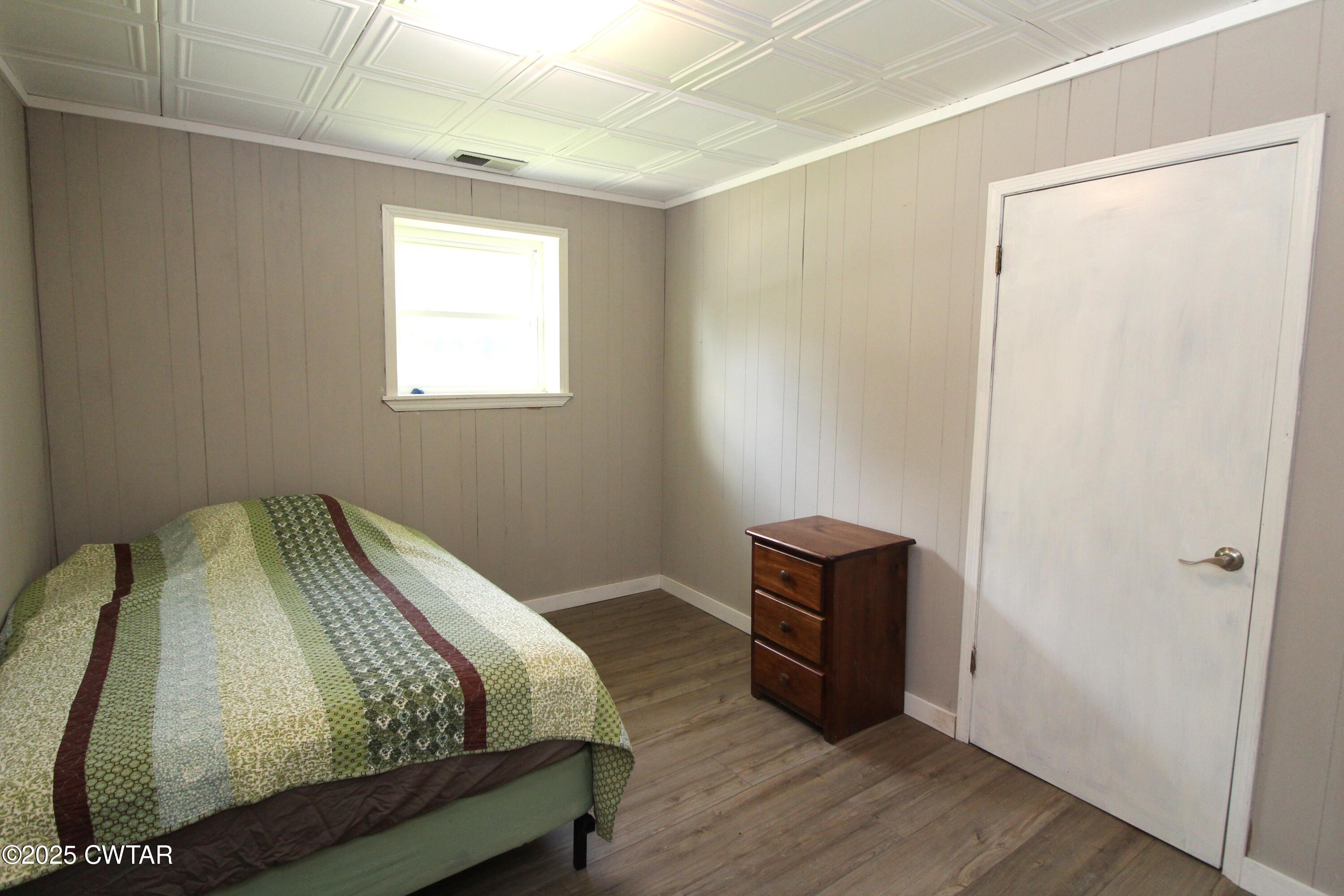 152 Hunter Jones Road Milan, TN 38358 - Photo 22 of 31 a bedroom with a bed and wooden floor