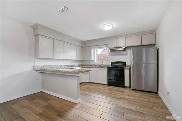 a kitchen with a refrigerator sink and cabinets