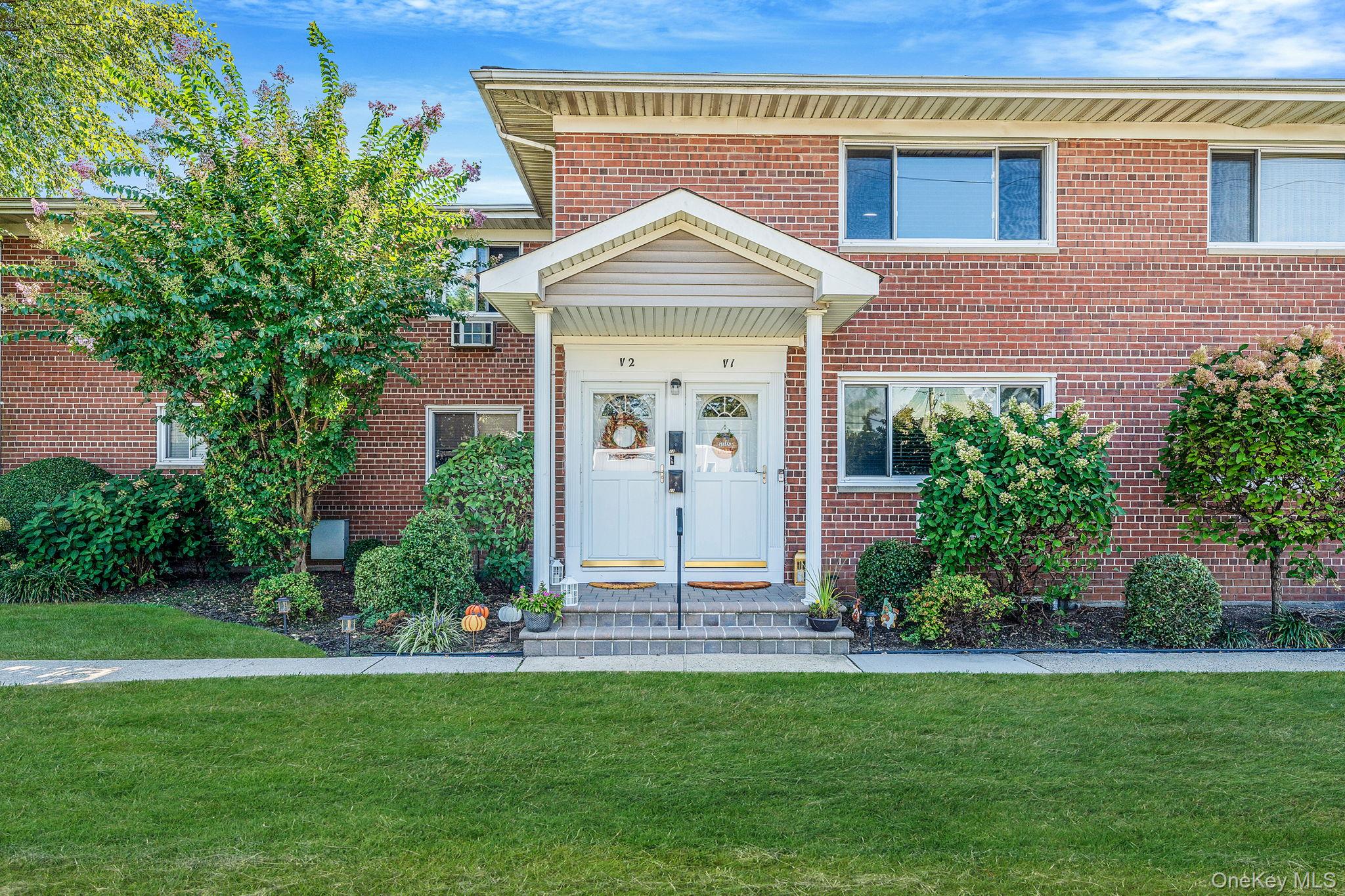 View of front facade with a front lawn and brick siding