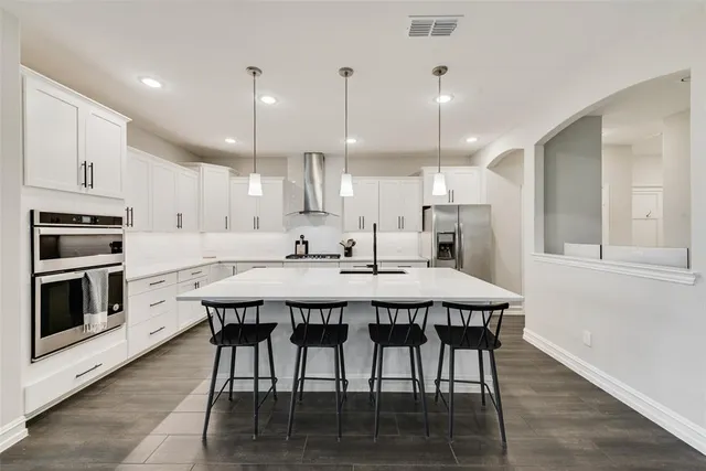 a large kitchen with a table and chairs