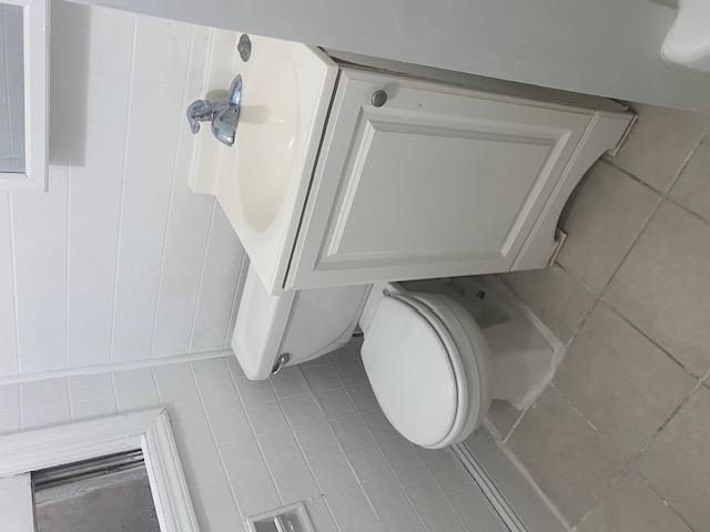 87-28 87th Street Queens, NY 11421 - Photo 12 of 15 a white toilet sitting next to a bathroom sink