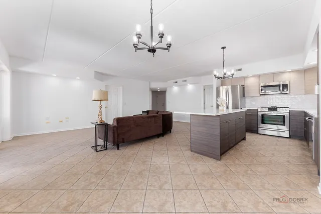 a living room with kitchen island furniture and a chandelier