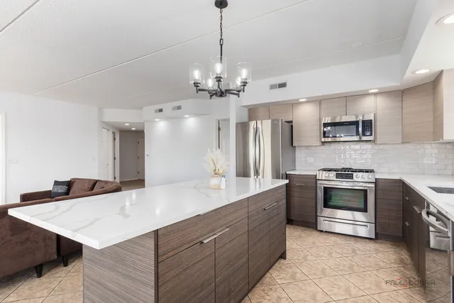 a kitchen with kitchen island a sink appliances and cabinets