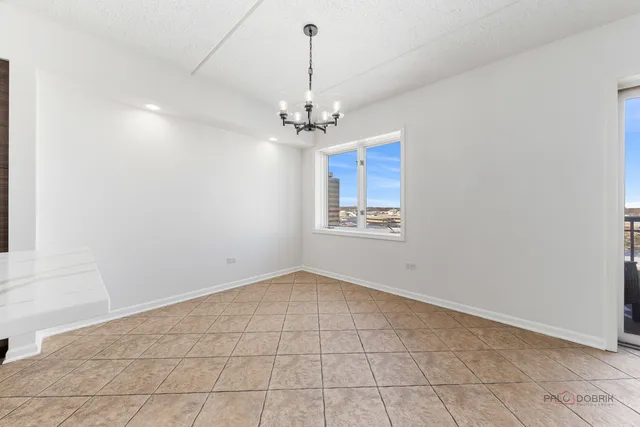 an empty room with windows and ceiling fan