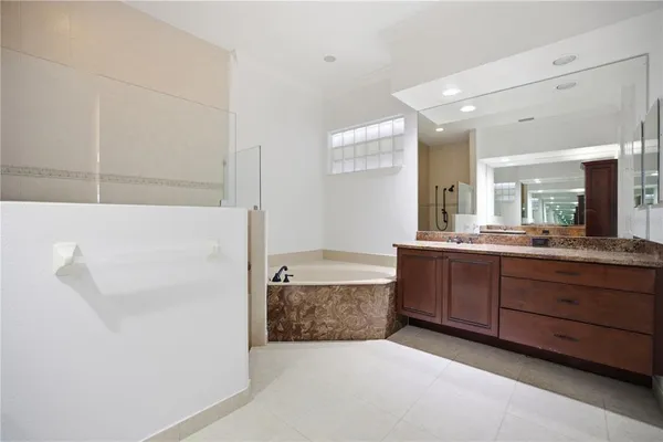 a bathroom with a tub sink and mirror