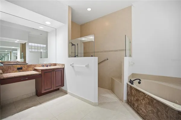 a large bathroom with a tub sink and mirror
