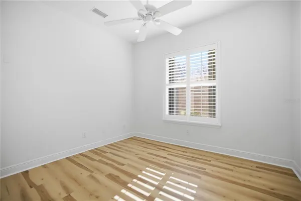 an empty room with a window and ceiling fan