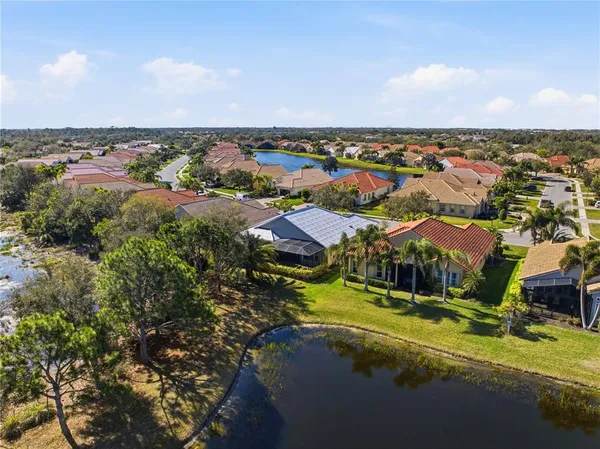 an aerial view of residential houses with outdoor space and trees