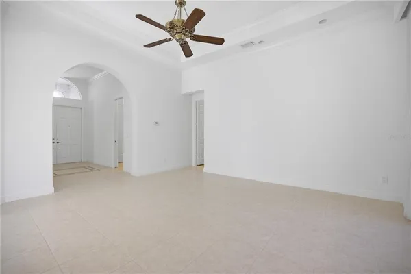 an empty room with closet and a ceiling fan