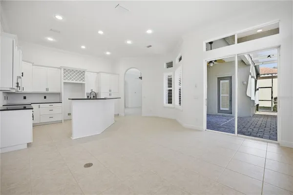 a view of a kitchen with refrigerator and white cabinets