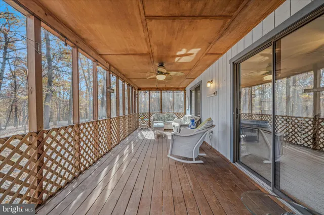a dining room with wooden floor glass walls and floor to ceiling window