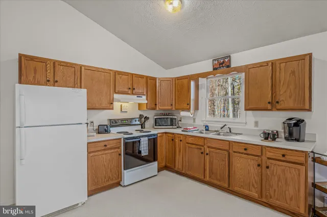 a kitchen with sink a microwave and cabinets