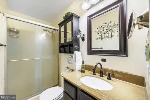 a bathroom with a granite countertop sink toilet and shower