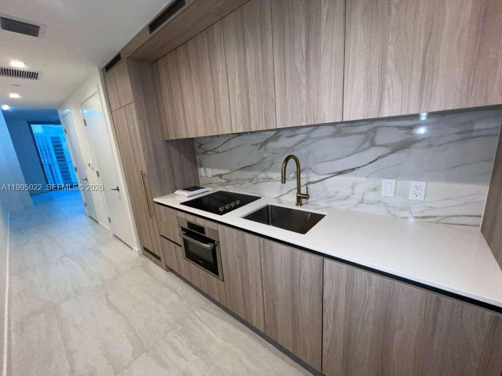 77 Southeast 5th, Unit 2004 Miami, FL 32311 - Photo 5 of 32 a kitchen with stainless steel appliances a sink a stove a refrigerator cabinets and a counter top space
