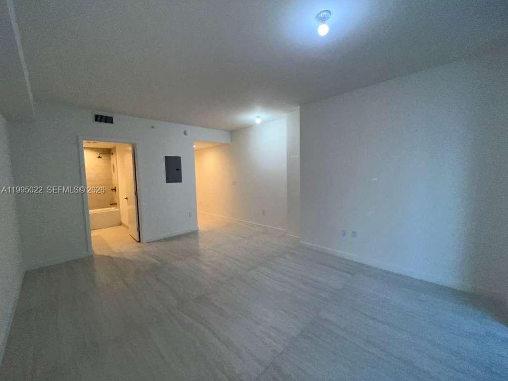 77 Southeast 5th, Unit 2004 Miami, FL 32311 - Photo 9 of 32 a view of an empty room with wooden floor and windows