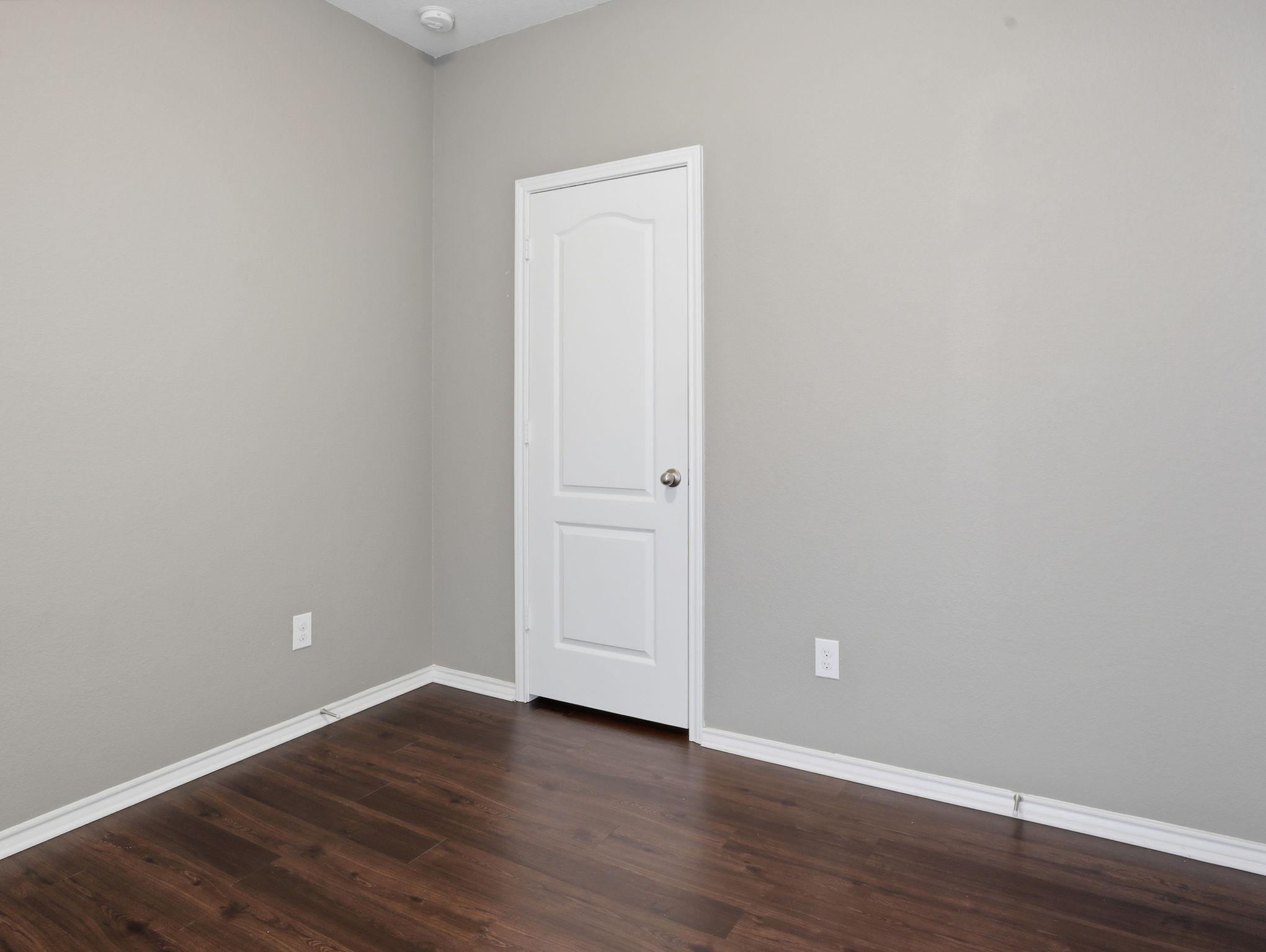 640 Landon Samuel Loop Pflugerville, TX 78660 - Photo 15 of 33 Room featuring wood-finish flooring, light gray walls, a white paneled door with a silver knob, white baseboards, and a recessed ceiling light