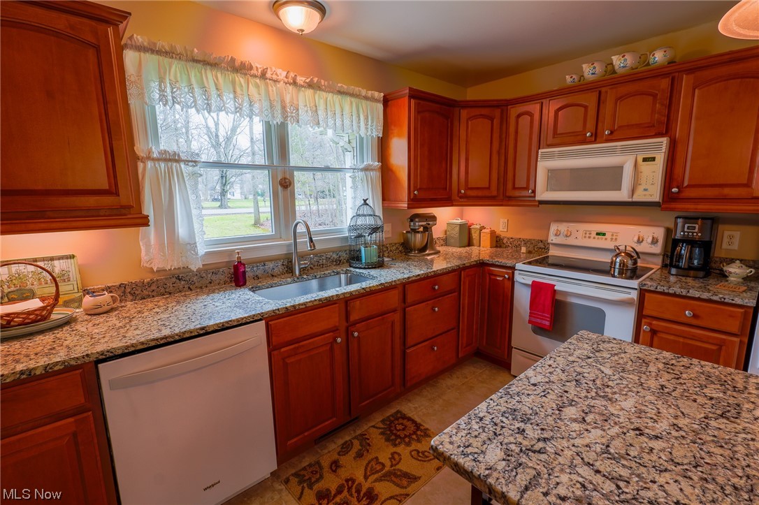 533 Middle Road Conneaut, OH 44030 - Photo 20 of 46 Kitchen featuring sink, light stone countertops, white appliances, and light tile floors