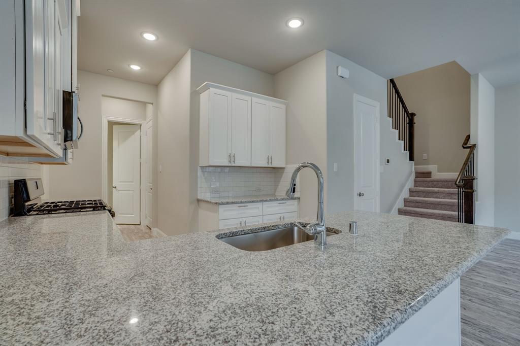 6217 Rainbow Valley Place Frisco, TX 75035 - Photo 12 of 30 a kitchen with stainless steel appliances granite countertop a sink and a stove top oven