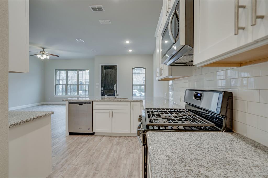 6217 Rainbow Valley Place Frisco, TX 75035 - Photo 13 of 30 a kitchen with a stove a sink and a refrigerator