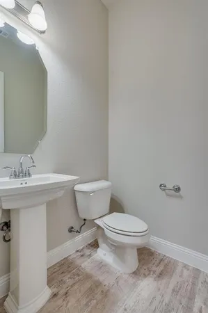 a bathroom with a sink a toilet and a mirror