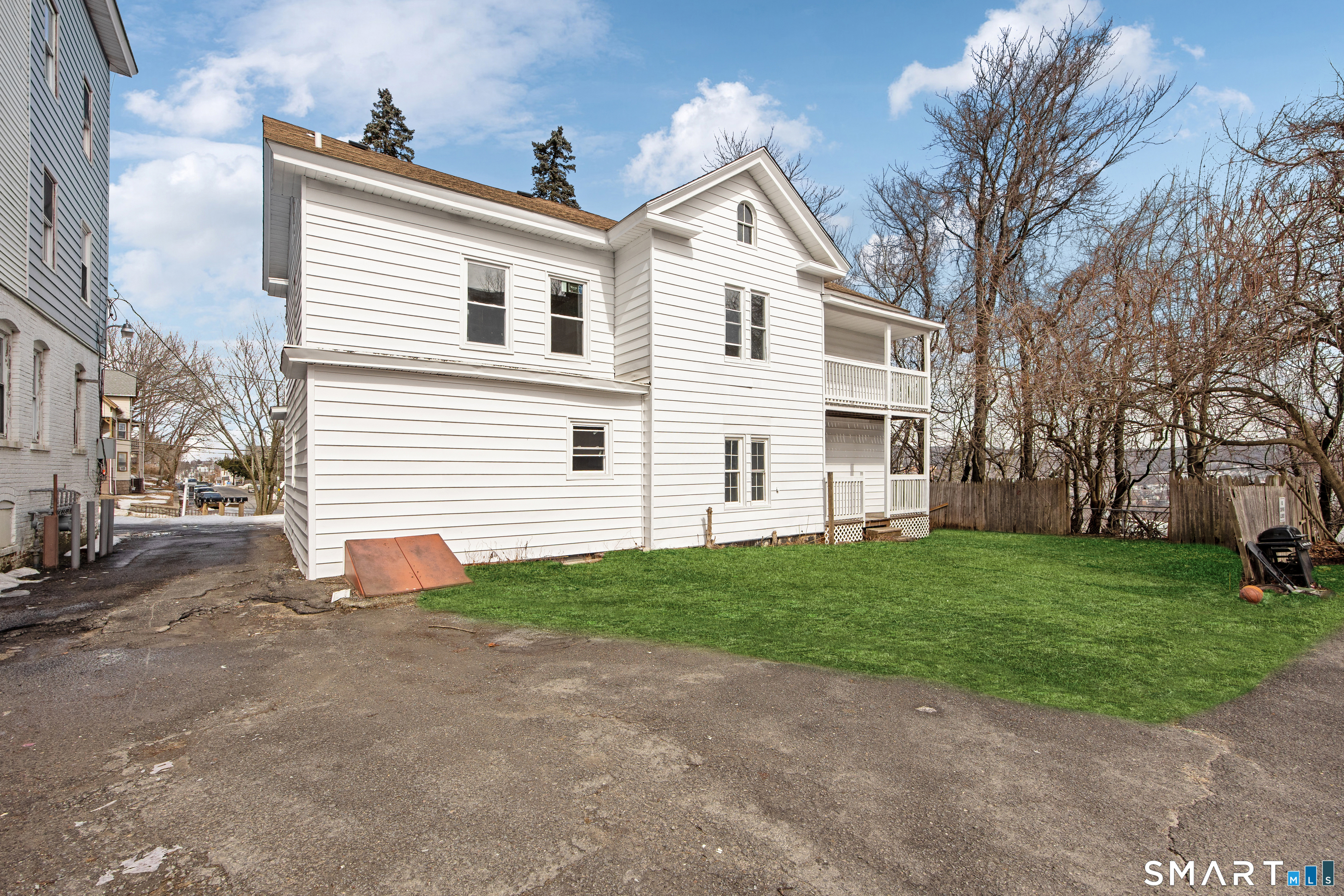 465 Washington Avenue Waterbury, CT 06708 - Photo 33 of 34 a view of a white house next to a yard and large trees